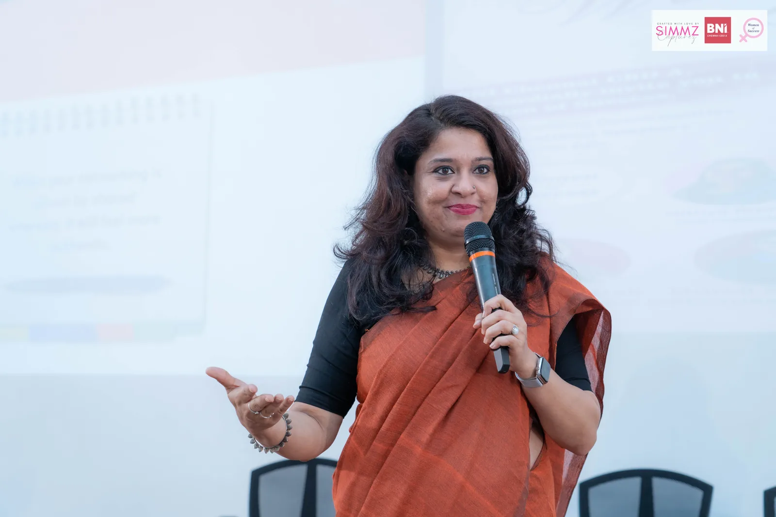 Meera Grover speaking with a microphone at a leadership event
